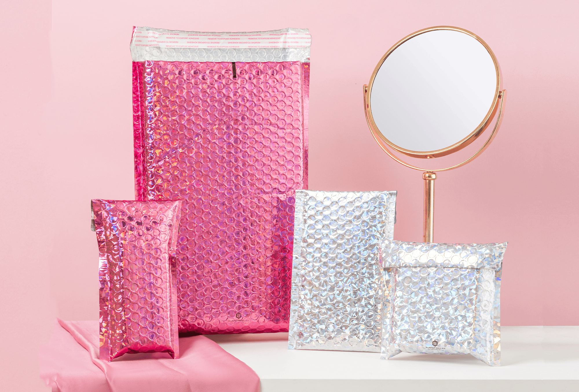 <p><strong>RUSFET Bubble Mailer Hologram Series (Silver Holo &amp; Pink Holo)</strong></p><p>RUSFET Bubble Mailer Hologram Series merupakan seri amplop pelindung eksklusif dengan efek <strong>hologram mengilap</strong> yang menampilkan kilauan warna dinamis dan elegan. Didesain menggunakan <strong>lapisan luar metalized holographic film</strong> yang tebal, tahan air, serta memberikan kesan modern dan premium.</p><p>Bagian dalamnya dilapisi <strong>bubble wrap berdensitas tinggi</strong> untuk perlindungan maksimal terhadap benturan, goresan, dan kelembapan. Dilengkapi <strong>perekat self-adhesive seal</strong> yang kuat, membuat proses pengemasan menjadi lebih praktis, aman, dan rapi tanpa memerlukan tambahan lakban.</p>